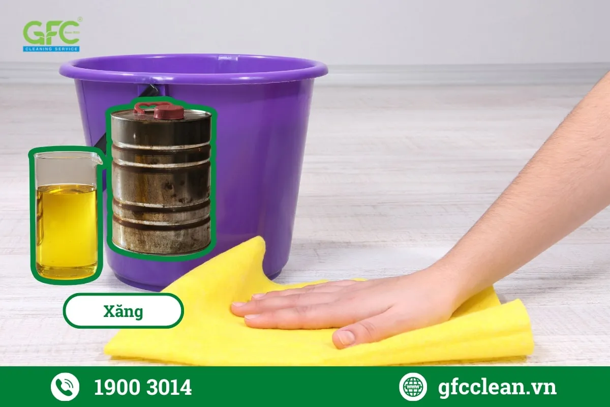 Sử dụng khăn mềm để thấm xăng đều lên vùng xi măng bám dính trên sàn