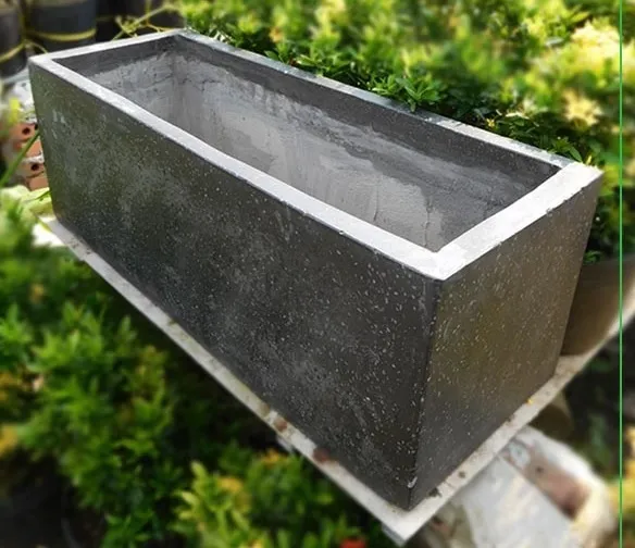 Bề mặt đá mài mịn màng của chậu xi măng hình chữ nhật giúp nâng tầm không gian kiến trúc