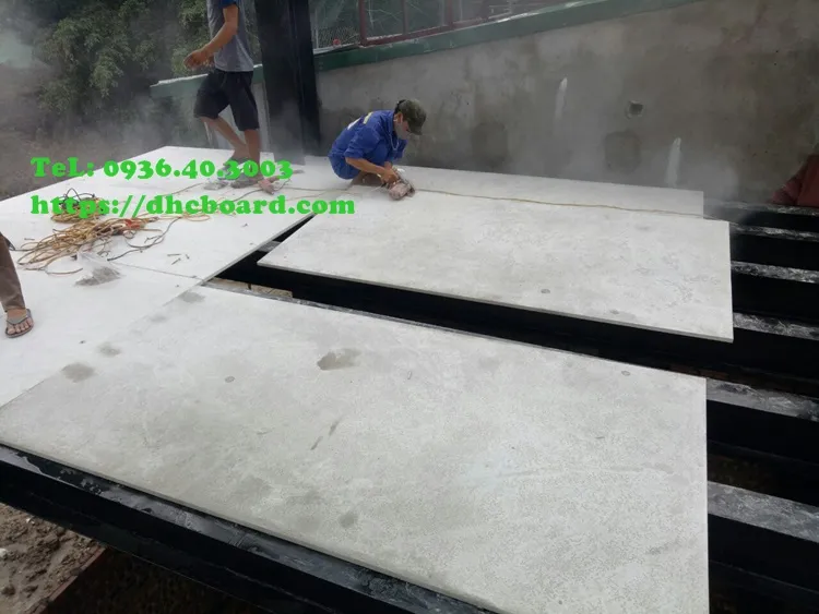 Công nhân đang cố định tấm sàn nhẹ bằng vít tự khoan chuyên dụng.